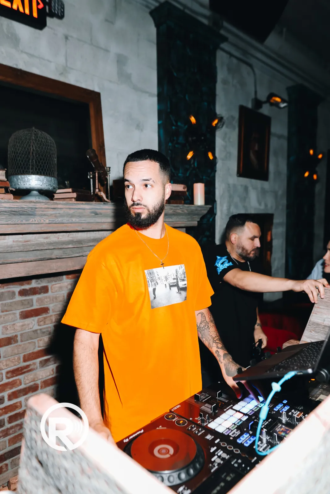 DJ Tury at a brick-wall booth