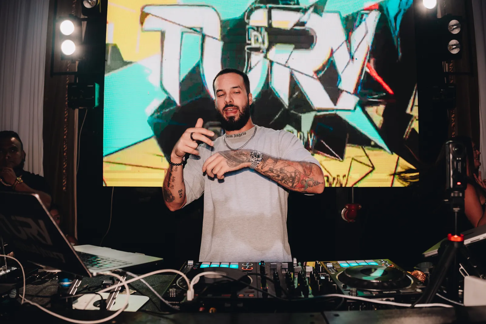 DJ Tury on stage in front of a TURY LED backdrop